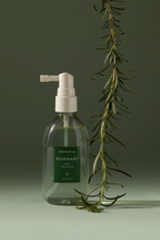 Load image into Gallery viewer, Bottle of Aromatica&#39;s Rosemary Root Enhancer against a soft green background, with a twig of Rosemary hanging down next to it.
