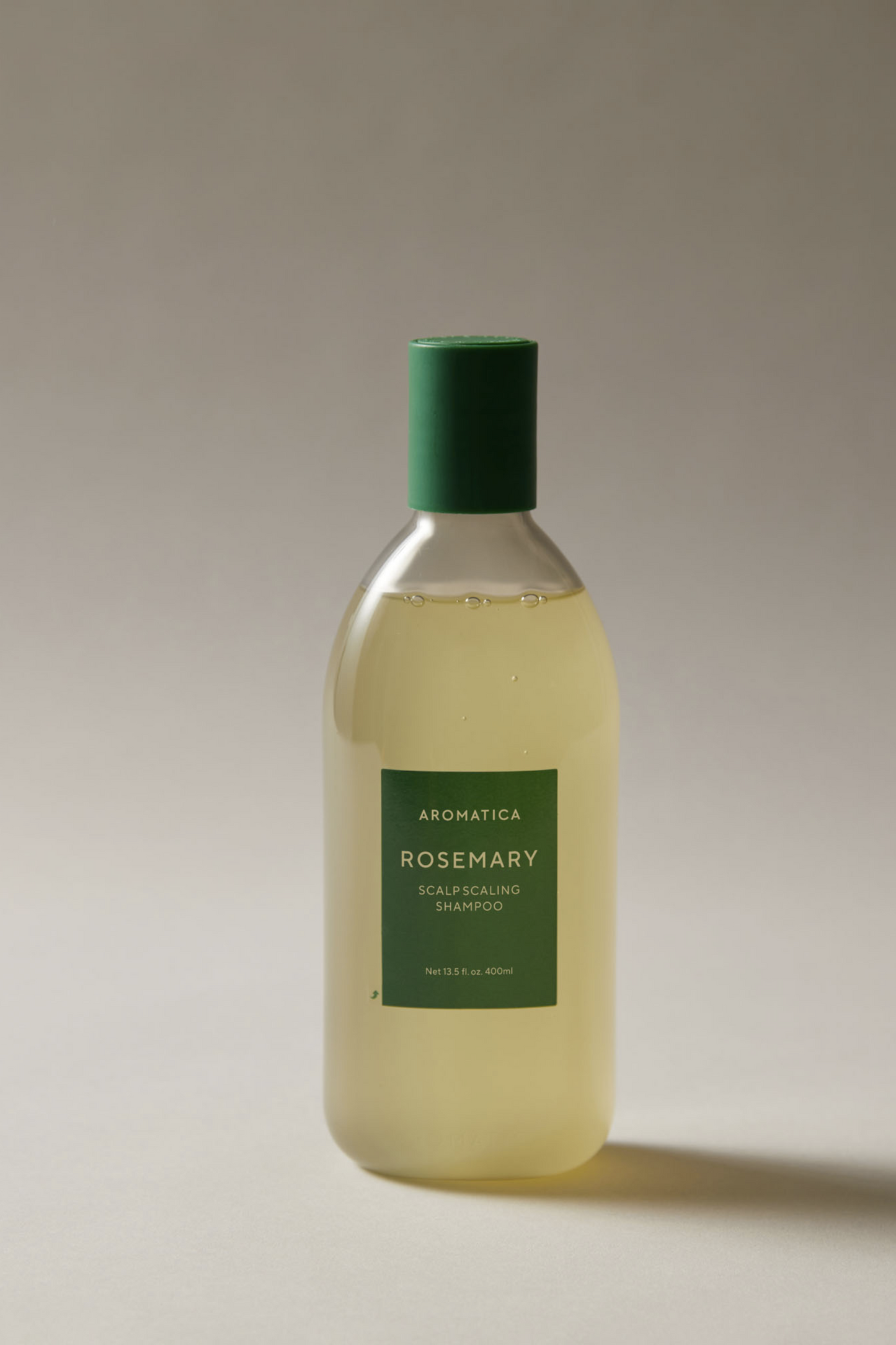 400ml bottle of Aromatica's Rosemary Scalp Scaling shampoo against a light grey background. Available for purchase at Sinless Skincare.