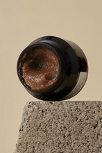 Lade das Bild in den Galerie-Viewer, Open jar of Klairs Gentle Black Sugar Facial Polish laying on its side so the contents are visible. It is on a grey stone against a beige background.
