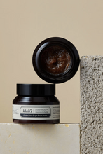 Lade das Bild in den Galerie-Viewer, Two jars of Klairs Gentle Black Sugar Facial Polish. One is standing upright and the other is on top of it, on its side with its lid off so the exfoliator is visible. It is leaning against a grey stone with a beige background.
