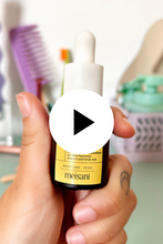 Load and play video in Gallery viewer, Close up of fingers squeezing the dropper of Meisani&#39;s Glow Drops Vitamin C Serum, against a yellow background.
