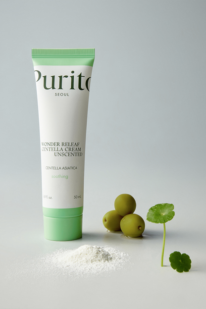 Purito's Wonder Releaf Centella Cream Unscented against a grey background with centella plant on the ground. Available for purchase at Sinless Skincare.