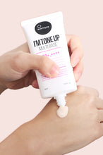 Load image into Gallery viewer, Tube of Suntique&#39;s Tone Up Multibase sunscreen being applied to someone&#39;s hand, against a beige background. Available for purchase at Sinless Skincare.
